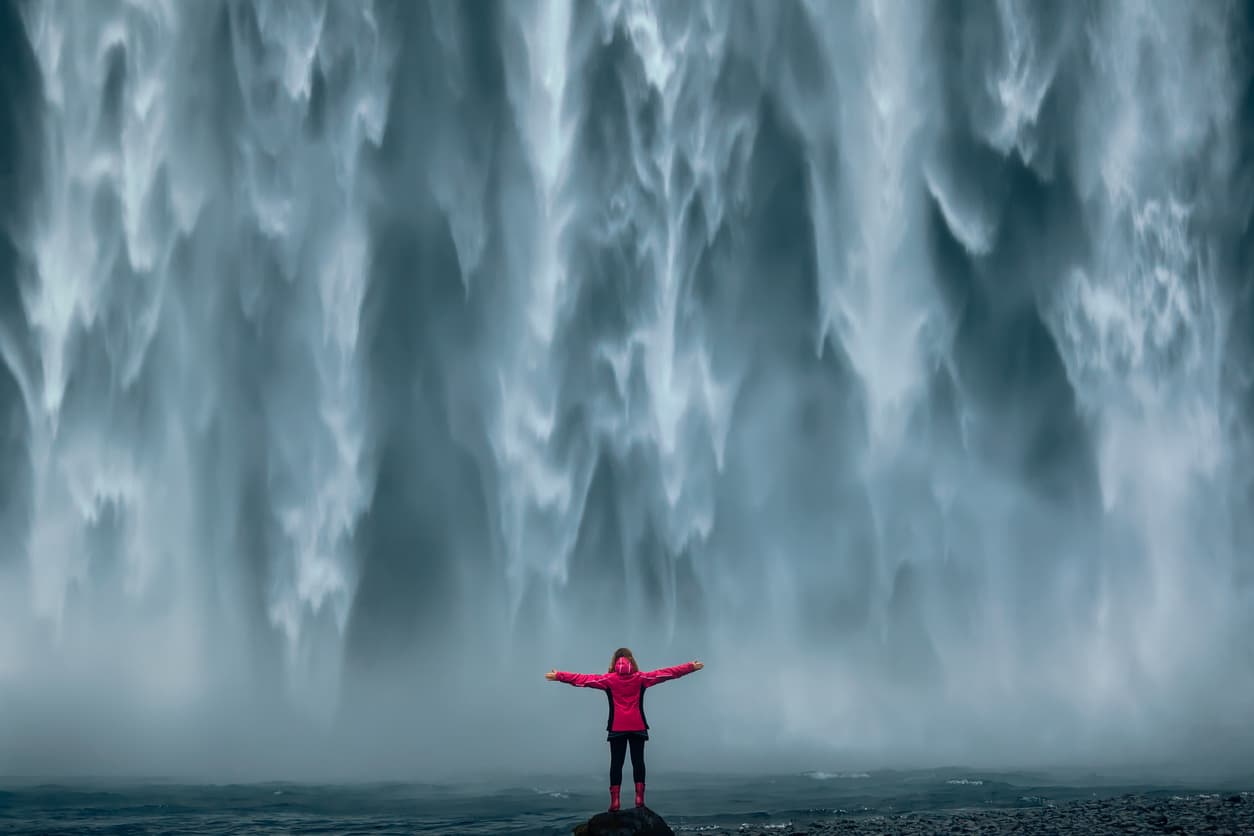 A person standing before a waterfall, representing reset and renewal